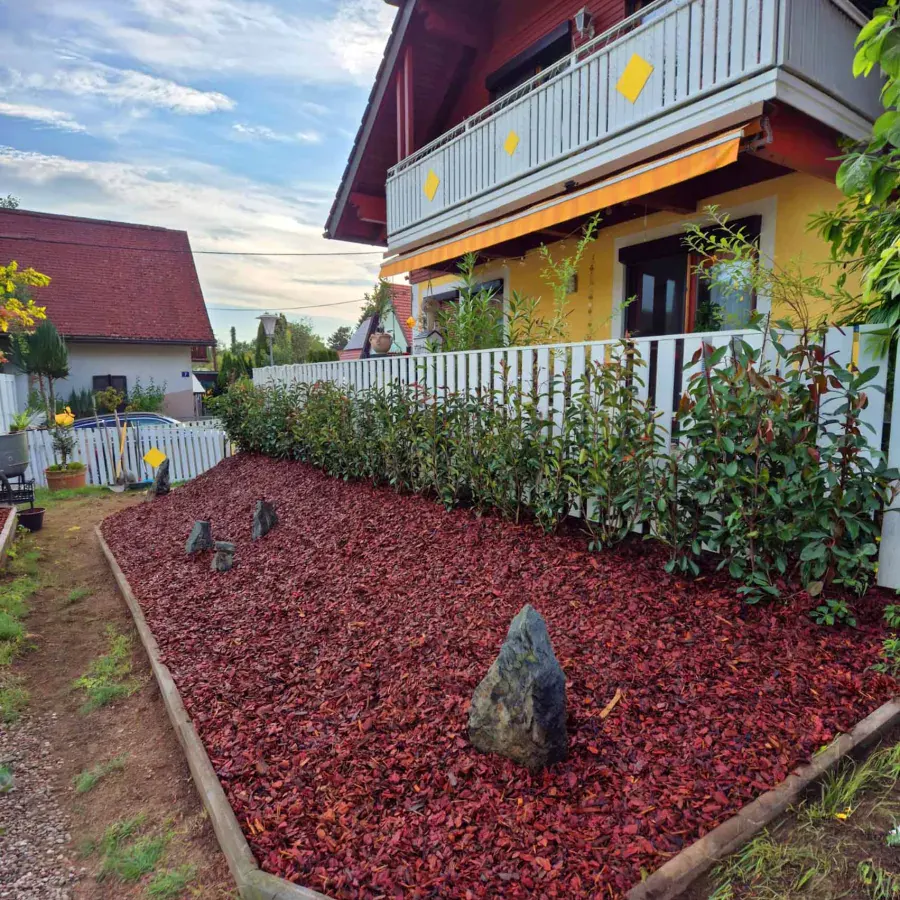 Gartenbereich mit Mulch, Sträuchern und klarer Beetkante